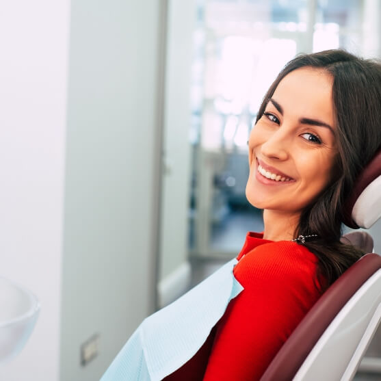 Woman in dental treatment chair smiling