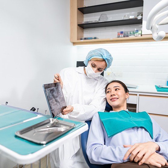 Dentist and patient conversing in treatment room