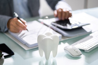 person calculating the cost of dental implants