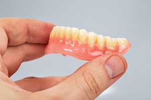 Close-up of hand holding a full denture