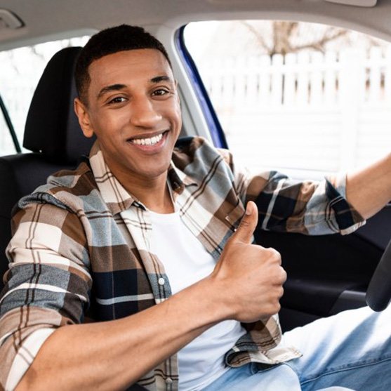 Man smiles in car?